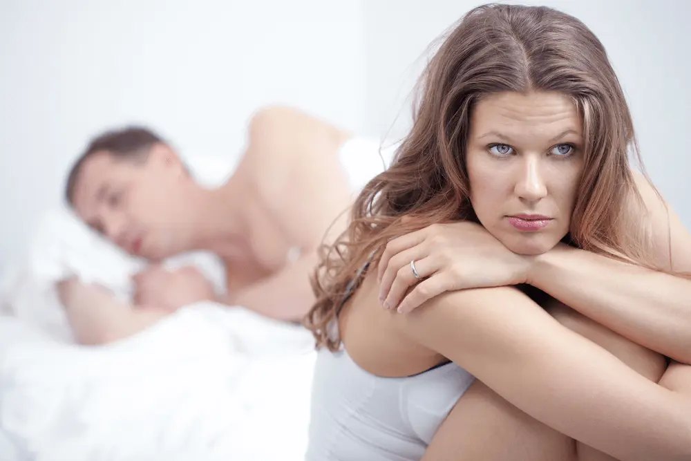 Ejaculatory Dysfunction Dissatisfied woman sitting by bed